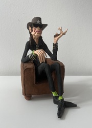 Udo Lindenberg, schwarz, sitzend im braunen Ledersessel, Ton-Unikate auf Gipssockel, Aquarell und Gouache, 2023, H: 25 cm